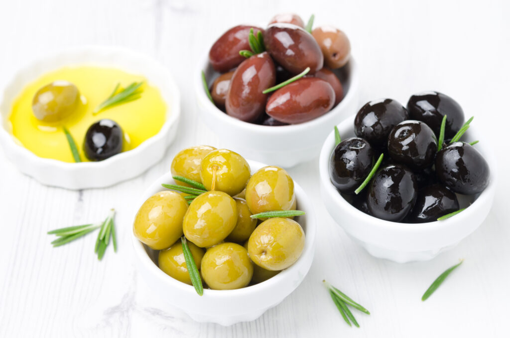 three kinds of olives in bowls, fresh rosemary and olive oil, ho